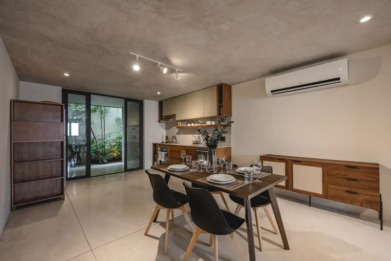 Comedor y cocina con muebles de madera y vista al patio