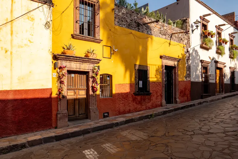 Calle empedrada del centro con fachadas coloniales amarillas y rojas