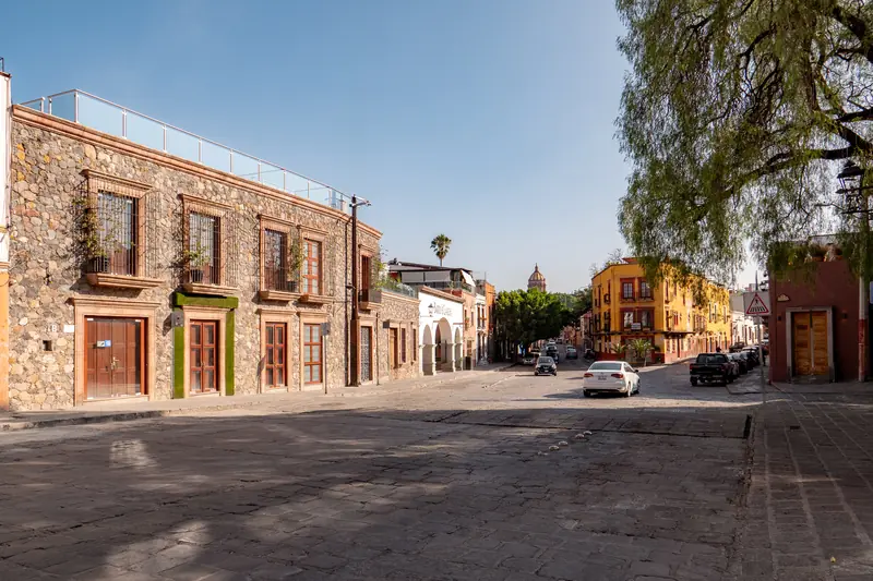Calle colonial de cantera con vista a las cúpulas