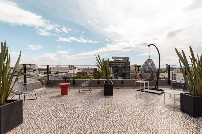 Roof garden con piso de pedrería, agaves y vista panorámica de la Roma Norte